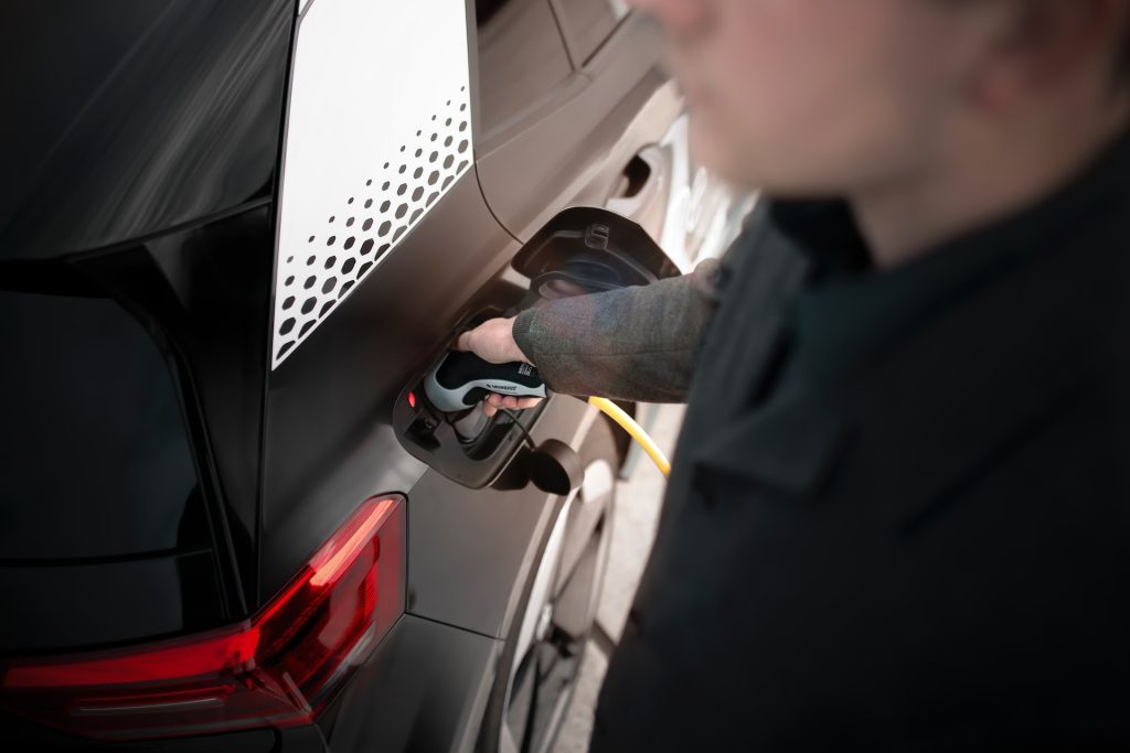 Man plugging in Electric Vehicle charger.