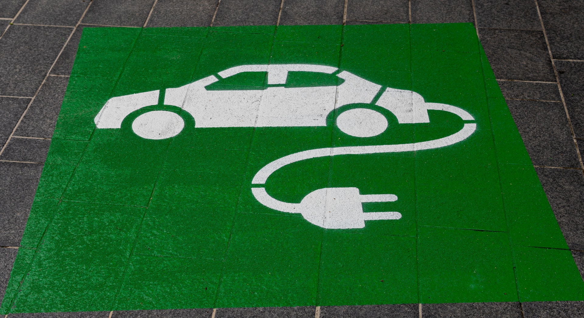 Green sign on the floor at a charging station.