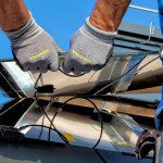 Men installling solar panels used in harnessing renewable energy source.