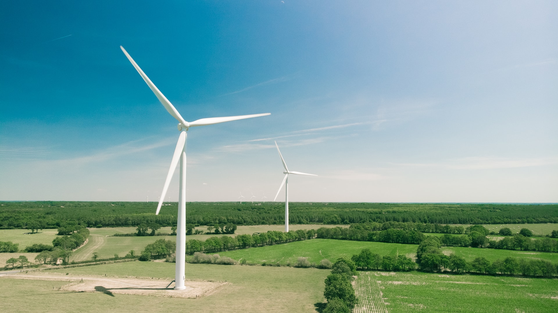 Big wind turbine on a green field, producing renewable energy.